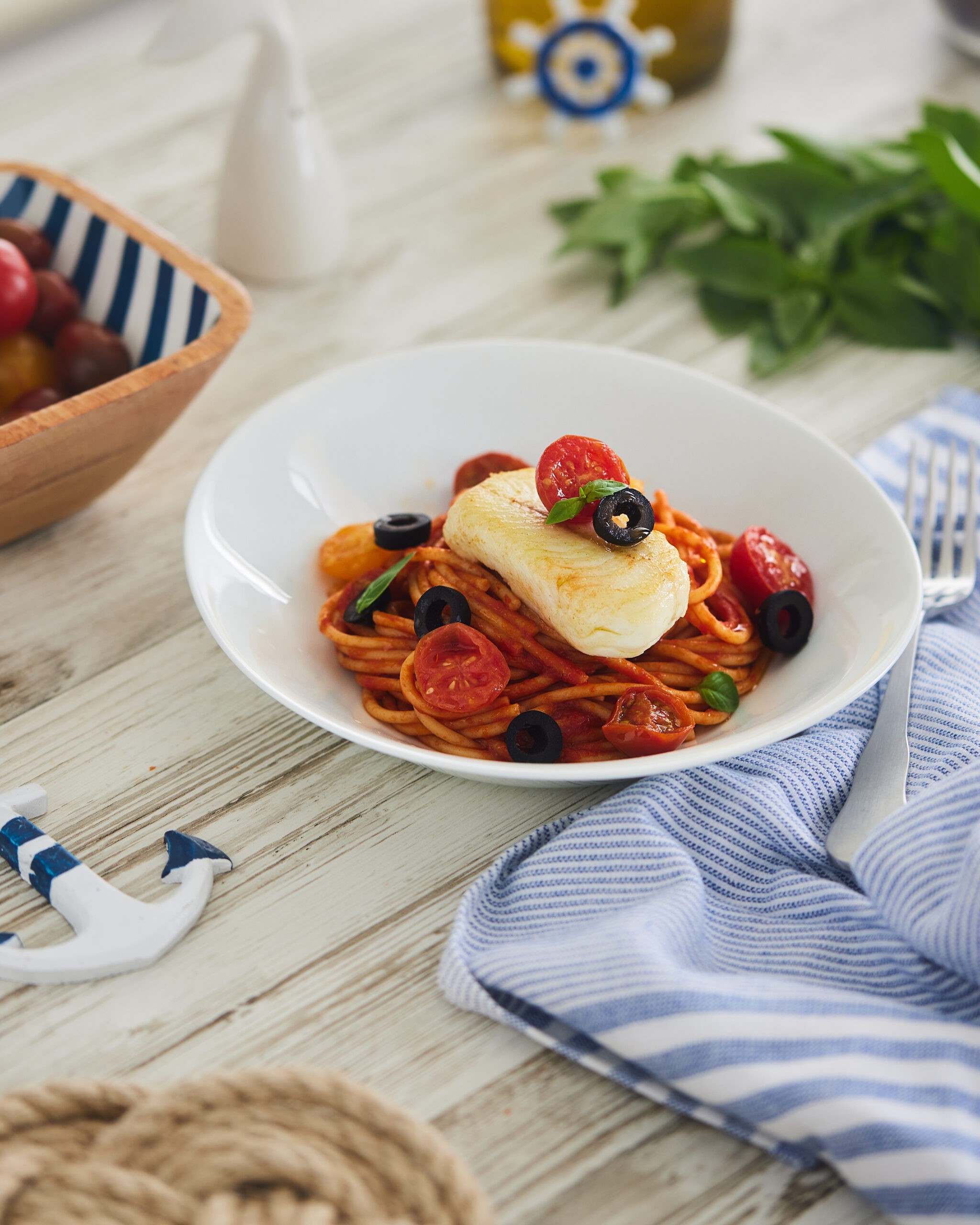 Corazones de merluza con pasta en salsa de tomate y aceitunas