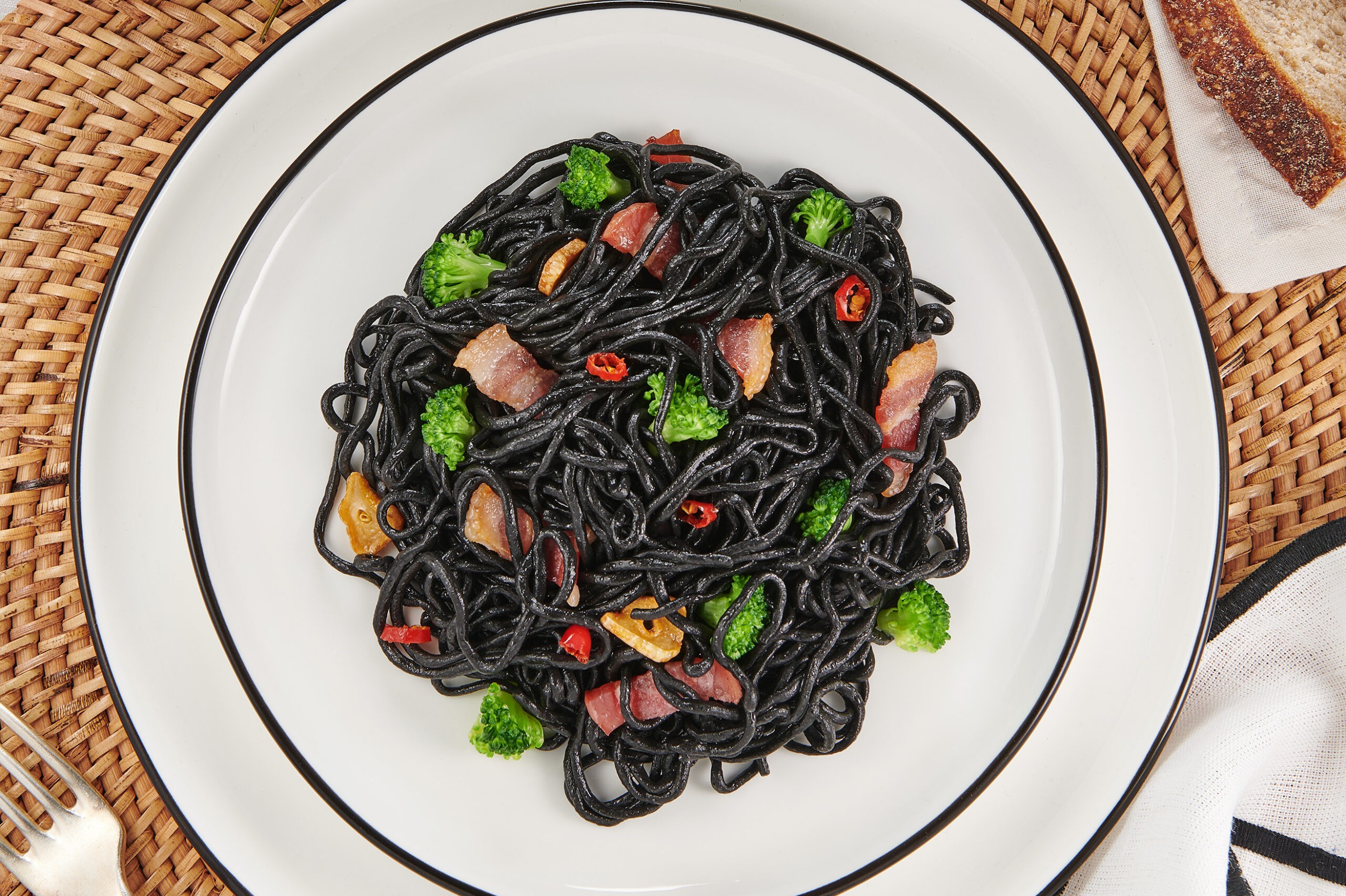 Espaguetis de merluza con tinta de sepia, bacon y brócoli